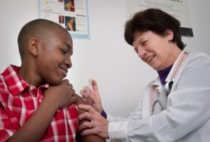 Photo of child receiving vaccine from a nurse.