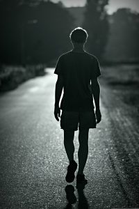 Monochrome image of man walking seen from behind