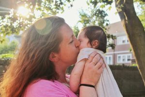 woman kissing baby on mouth