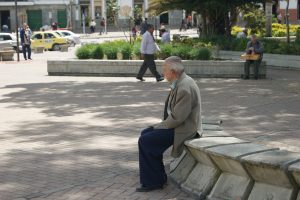 Old man sitting alone in town square