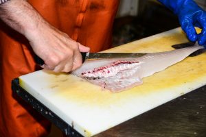 A person filleting a fish.