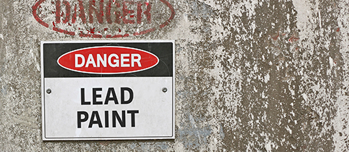 An image of an old wall with a sign reading "Danger Lead Paint"