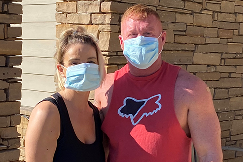 Man and woman wearing surgical masks, just vaccinated against COVID-19