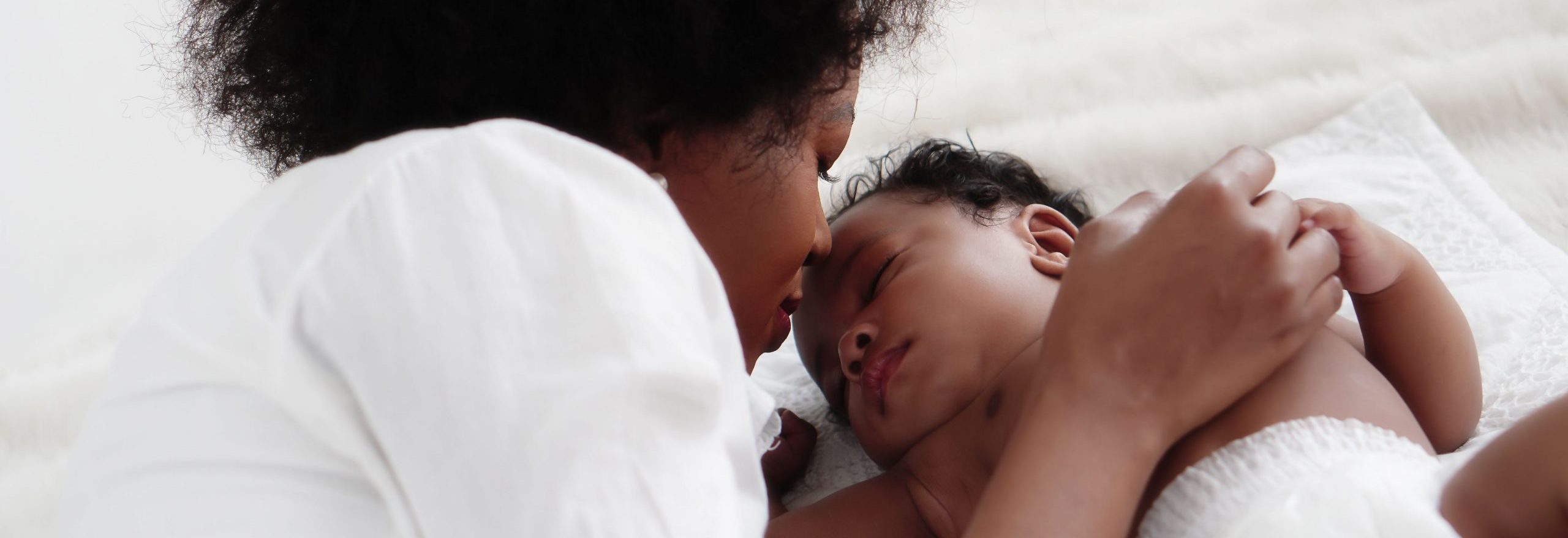 portrait of sleeping african american baby girl with mother