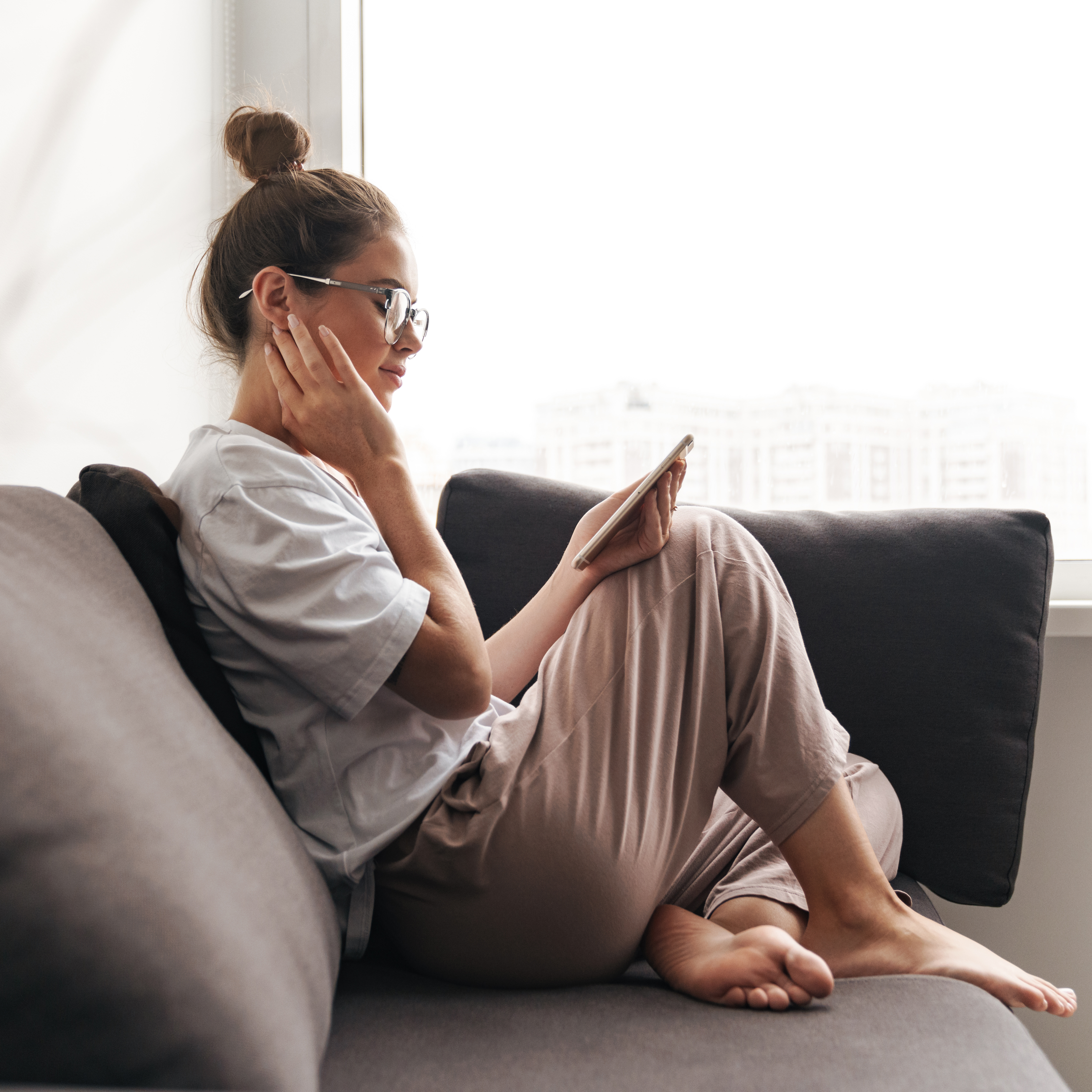 Girl sitting on sofa looking at phone