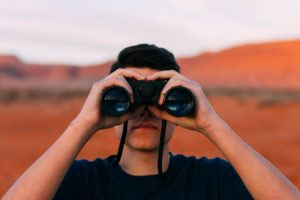 man looking through binoculars