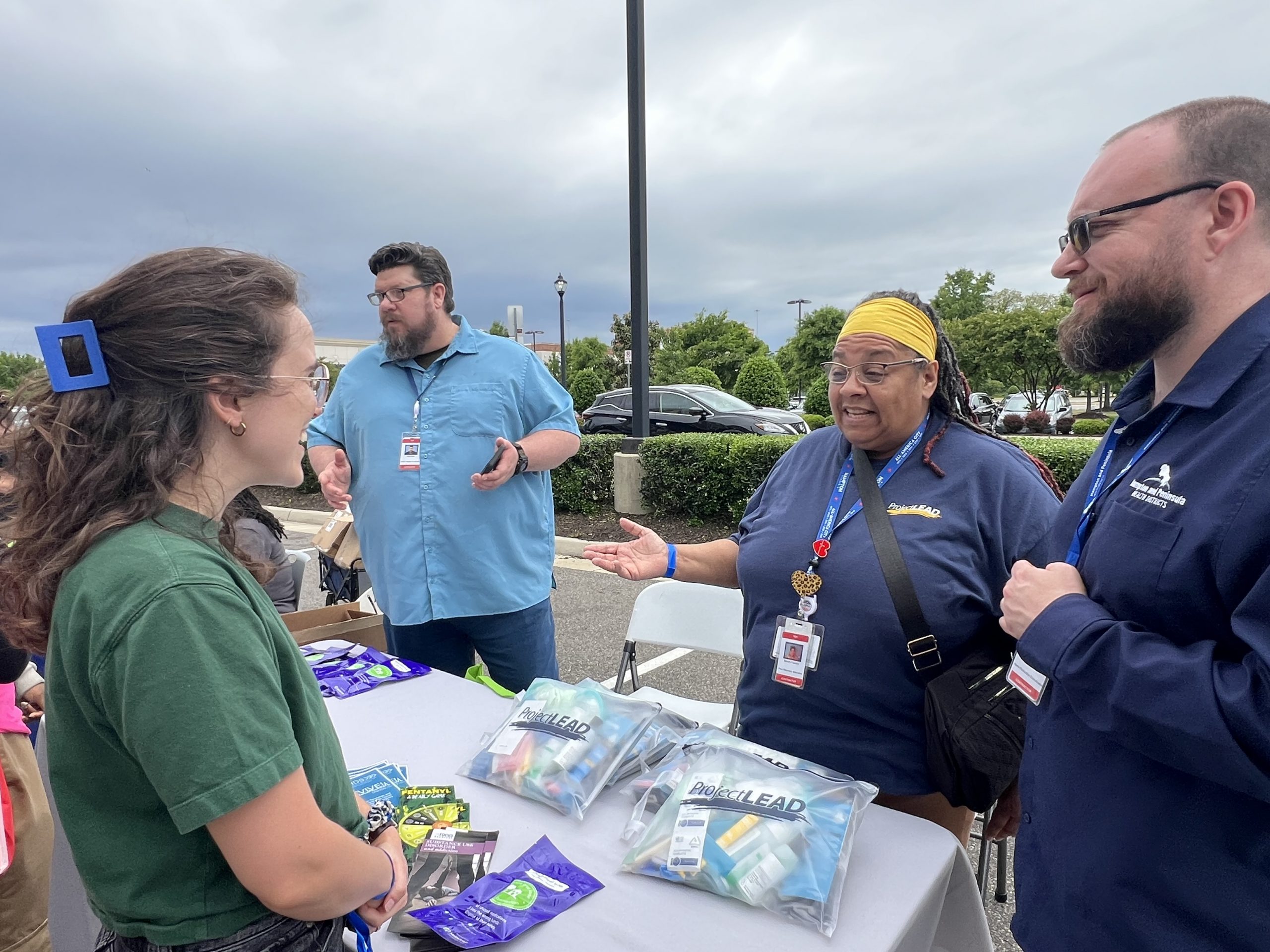 Picture of community member engaging with HPHD's Harm Reduction staff regarding our hygiene kits.