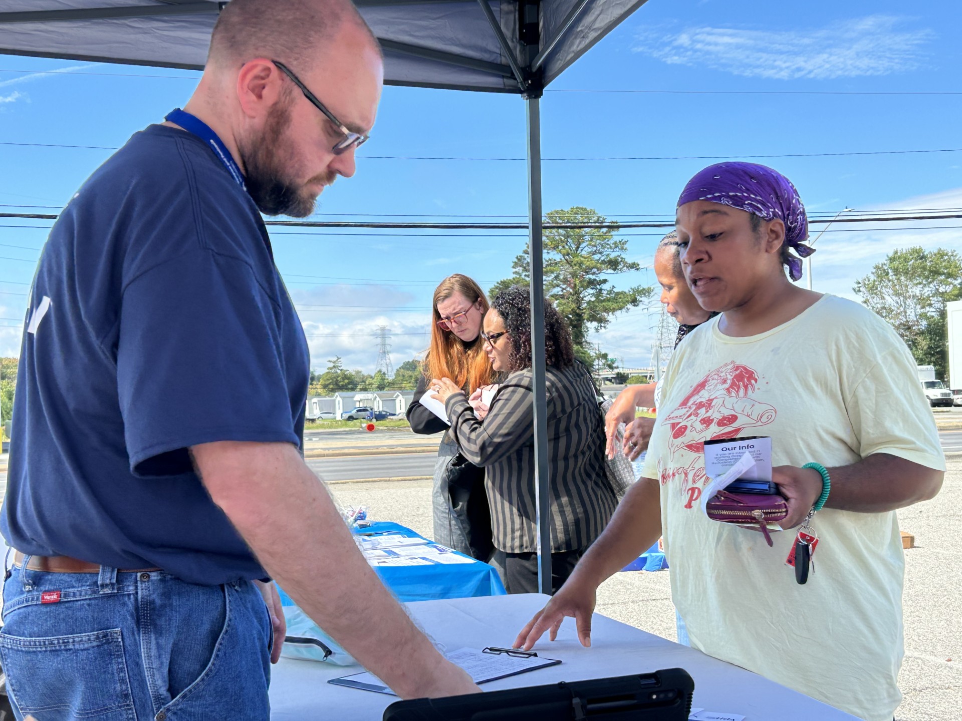 Picture of our Harm Reduction Coordinator providing information to a community member.