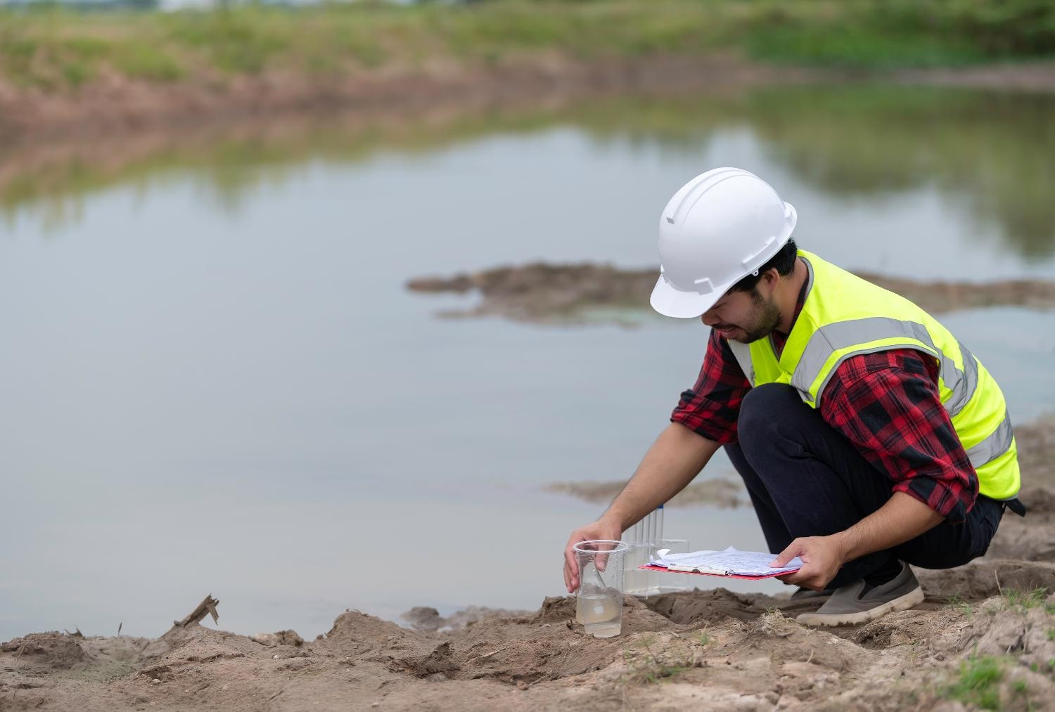 Public health worker collecting a water sample to support environmental health and safety