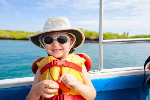 Adorable little girl in a life jacket traveling on boat