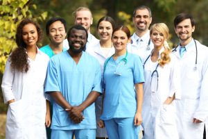 Image of people of different races, genders, etc. dressed in medical professional uniforms. 