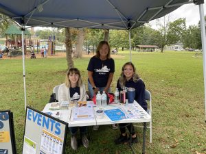 Three CVHD staff members behind a table with resources at an outdoor event.
