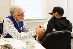 Một người băng bó cánh tay của người khác.