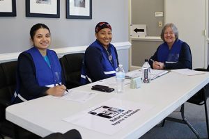 Ba người mỉm cười sau một cái bàn.