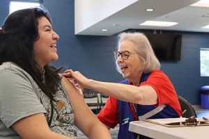 Một người đang cười với một người khác tại một bàn ăn.