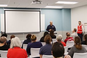 Một người đang phát biểu trước một căn phòng đầy người.