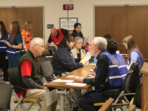 People sit at tables discussing vaccinations.