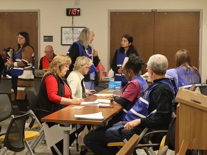 People sit at a table during a vaccination event.